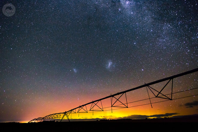 Center pivot irrigator silhouetted by the Aurora Australis, Mid-Canterbury, New Zealand, landscape