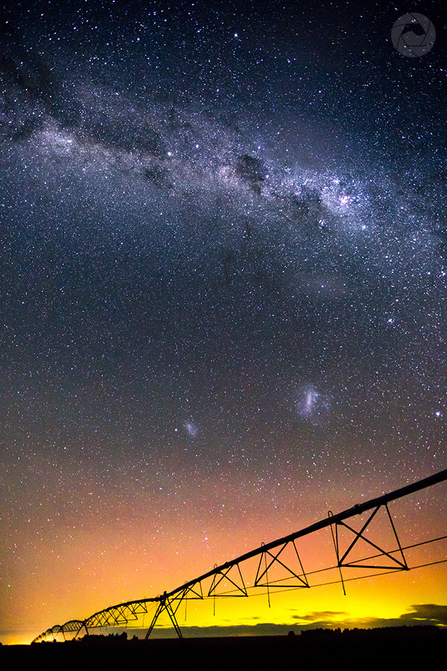 Center pivot irrigator silhouetted by the Aurora Australis, Mid-Canterbury, New Zealand, portrait